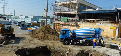 Foto van een bouwterrein in de zomer: De nieuwe consistentieverhogers van het MC-PowerFlow productgamma gaan de toegenomen verstijving van het transportbeton tegen en zorgen voor een langdurige consistentie.